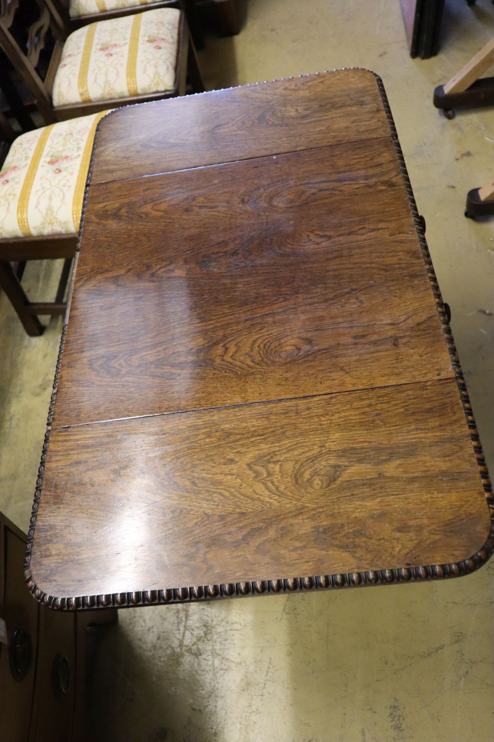 A William IV rosewood drop-flap sewing table, fitted two frieze drawers, carved with acanthus to end supports and feet, width 53cm dept